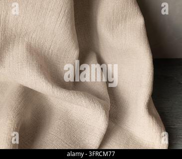 Tessuto di lino beige con pieghe morbide drappeggiate e texture tessuta naturale Foto Stock