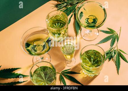 Bevanda alla canapa SBD in diversi bicchieri, sfondo creativo verde con ombre dure. Riposo relax energia rilassante cocktail alla cannabis. Cornice orizzontale da copiare Foto Stock