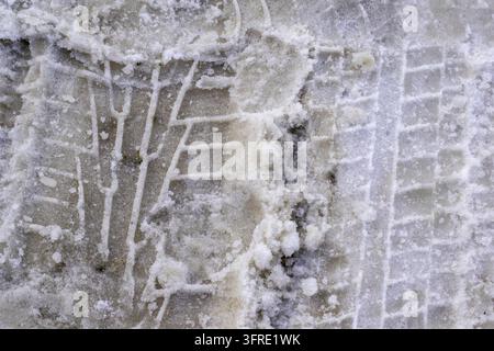 Tracce di pneumatici su strada innevata.Strada coperta di neve, guida invernale Foto Stock