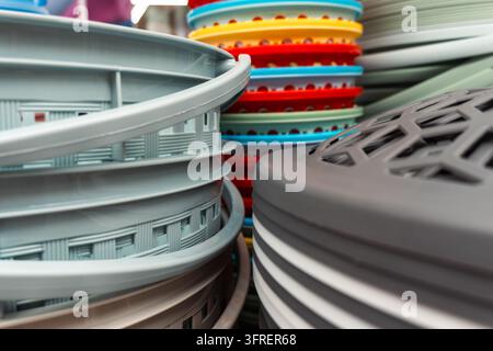 Cestini di plastica e contenitori per la casa sono impilati su un espositore di un negozio a Da Lat, Vietnam. Foto Stock
