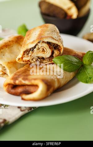 Crepe ai funghi saporite servite con basilico su sfondo verde . Foto Stock