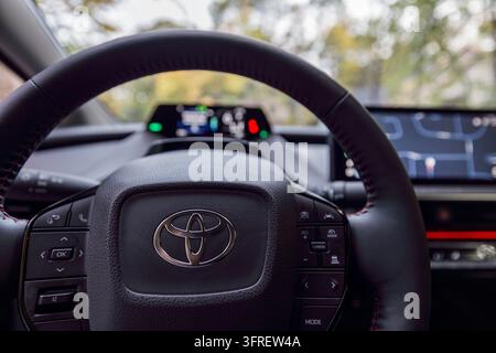 Montreal, Canada – 11 ottobre 2026: Vista del conducente del cockpit di una Toyota Prius che mostra l'emblema del volante, l'HUD illuminato e la tecnologia del cruscotto Foto Stock