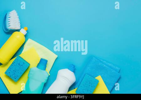 Kit di pulizia detersivi tovaglioli spugne guanti, sfondo blu. Il concetto di pulizia domestica o servizi di aziende di pulizia. Flat lay vista dall'alto spazio copia Foto Stock