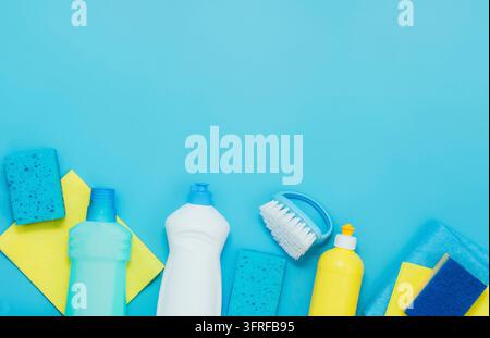 Kit di pulizia detersivi tovaglioli spugne guanti, sfondo blu. Il concetto di pulizia domestica o servizi di aziende di pulizia. Flat lay vista dall'alto spazio copia Foto Stock