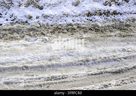 Tracce di pneumatici su strada innevata.Strada coperta di neve, guida invernale Foto Stock