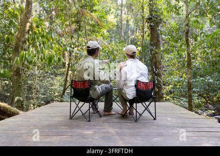 Una donna e un uomo stanno parlando davanti alla tenda da campeggio. Gita con la famiglia, campeggio nella foresta, attività all'aperto. Foto Stock