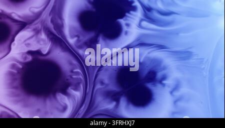 Miscela di vernici. Versamento di gocce. Goccia di liquido chimico di colore blu viola sfocata che si diffonde su uno sfondo creativo astratto. Foto Stock