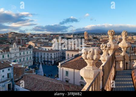 Palazzi barocchi, tetti in terracotta e decorazioni natalizie viste da una terrazza sul tetto nella vecchia città di Catania, Sicilia, Italia, con l'Etna in lontananza Foto Stock