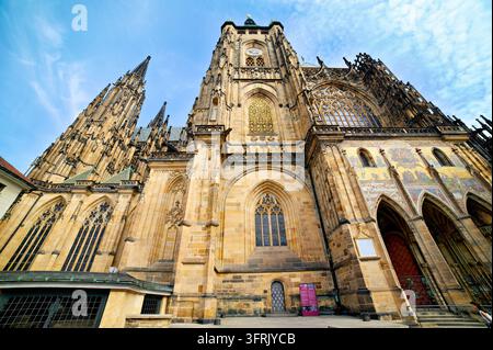 Vista a bassa angolazione della cattedrale gotica con il mosaico del Portale dorato e le guglie al Castello di Praga, Hradcany, Repubblica ceca, in una mattina d'estate. Foto Stock