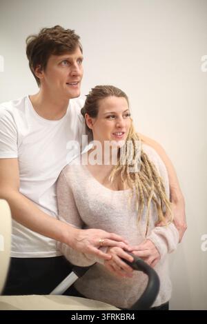 Un uomo e una donna si abbracciano. La donna ha lunghe dreadlocks. L'uomo indossa una camicia bianca Foto Stock