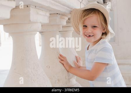 Ragazzo adorabile con cappello di paglia che sorride all'aperto Foto Stock