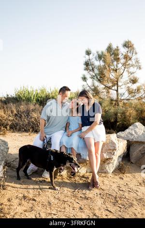 Famiglia asiatica felice che si diverte all'aperto con il suo cane Foto Stock