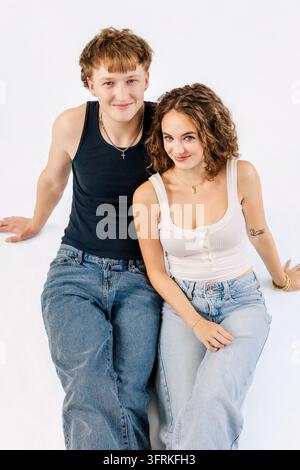 Coppia giovane e attraente che posa insieme su sfondo bianco Foto Stock