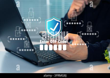 Una persona inserisce il codice OTP sul telefono vicino al laptop. Uno scudo digitale simboleggia la sicurezza. Mani concentrate mostrano un'autenticazione attenta. Ideale per siti web, app, Foto Stock