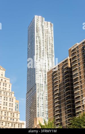 Vista ad angolo basso di stili architettonici contrastanti a Manhattan, New York City, con grattacieli moderni in vetro che circondano un edificio tradizionale in pietra Foto Stock