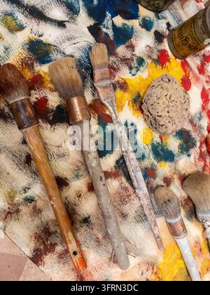 disposizione di pennelli per artisti e altre attrezzature sul tavolo da lavoro Foto Stock