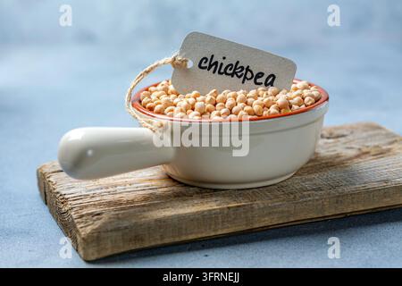 Grano di ceci crudo in una ciotola di ceramica etichettata Foto Stock
