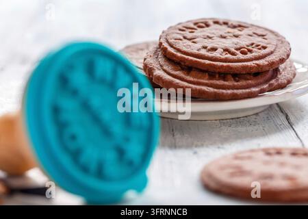Shortbread fatto in casa e tagliabiscotti a stampo su tavolo di legno bianco, messa a fuoco selettiva Foto Stock