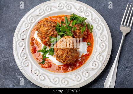 Polpette fatte in casa con carne, riso e verdure sono servite in un piatto su uno sfondo scuro. Vista dall'alto, primo piano Foto Stock