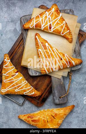 Frittelle di mele e cannella sono servite su una tavola di servizio in legno con uno sfondo di cemento texture. Vista dall'alto, flat lay Foto Stock