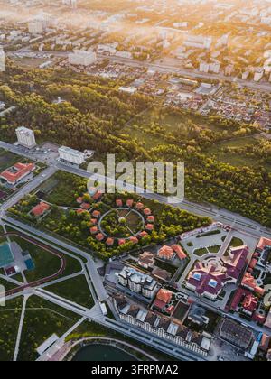 Vista ad angolo alto di un parco paesaggistico con percorsi circolari e giardini circondati da edifici urbani a Bishkek Foto Stock