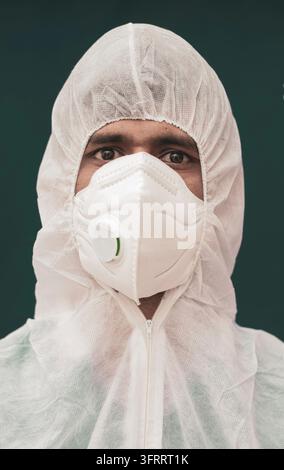 Ritratto ravvicinato di un medico con tuta protettiva e mascherina medica N95 che guarda verso l'obiettivo - Concetto di medici nello screening del coronavirus o COVID-19 Foto Stock
