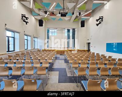 Mosca – 25 agosto 2025: Grande aula con una lavagna blu sul muro. Le sedie sono disposte a file e la stanza è vuota in una scuola rinnovata durante la giornata delle porte aperte Foto Stock