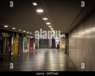 BELGRADO, SERBIA - 13 GIUGNO 2026: passaggio sotterraneo vuoto a Terazije a Belgrado, in Serbia, con negozi chiusi. Scale e una scala mobile portano verso Foto Stock