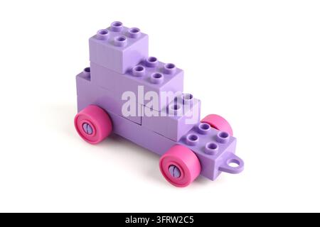 Creatività e sviluppo dell'infanzia, auto giocattolo viola costruita con blocchi di plastica isolata su sfondo bianco per concetti di gioco educativo Foto Stock