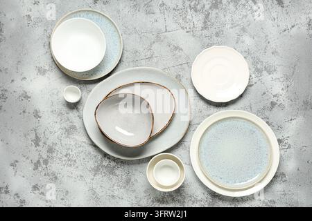 Presentazione minimalista di pasti e cibo, collezione di piatti e ciotole in ceramica su uno sfondo in cemento grigio strutturato per la fotografia dello stile di vita culinario Foto Stock