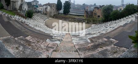Vista panoramica dai sedili in pietra dell'antico teatro romano di Verona, che mostra l'auditorium semicircolare e le rovine archeologiche. Foto Stock