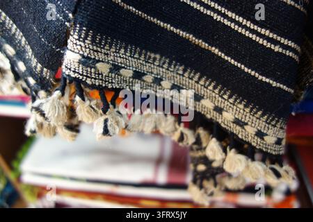Prima di un tessuto Bhujodi indiano tradizionale tessuto a mano con motivi geometrici e nappe a frangia, sfondo autentico dell'artigianato del telaio a mano del Kutch Foto Stock