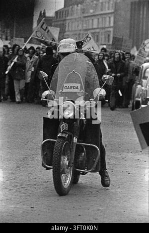 Dimostrazione a Dublino (presumibilmente per protestare contro l'Accordo Anglo-Irlandese): un motociclista della Garda guida la processione. Dublino, Irlanda, 1985. Foto Stock