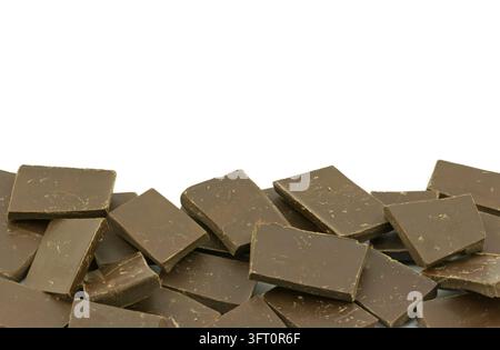 Prima vista di più pezzi di cioccolato fondente disposti in pile stratificate su uno sfondo bianco, che mostrano il ricco colore marrone e la consistenza Foto Stock