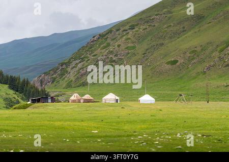 Yurte tradizionali nella valle di Kok-Kiya circondate da montagne verdi a Naryn, Kirghizistan Foto Stock