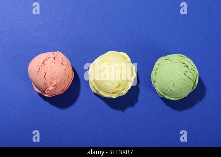 Tre palline di gelato su sfondo blu Foto Stock