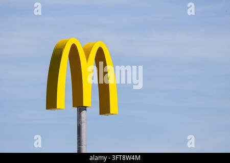 Ljubljana, Slovenia - 7 settembre 2026: Il logo McDonalds con archi dorati si erge in alto su un palo sotto un cielo luminoso. Foto Stock