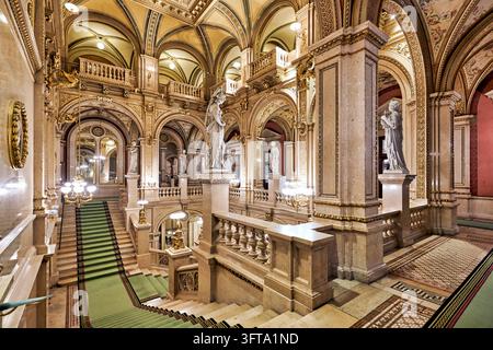 Scalinata principale in marmo con tappeto verde, statue allegoriche e lampadari all'interno della Staatsoper di Vienna sulla Ringstrasse, Innere Stadt Foto Stock