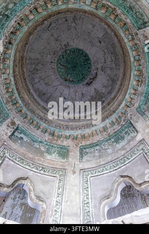 Guarda verso l'alto di un vecchio soffitto a cupola con anelli decorativi concentrici e intonaco scrostato intorno a due aperture ad arco, Bengala Occidentale, Kolkata, India Foto Stock