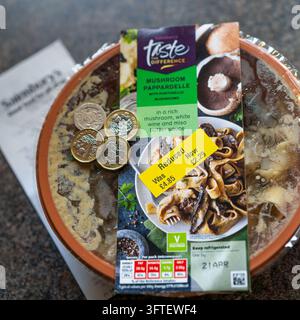 Adesivi gialli ridotti su alimenti di un supermercato nel Regno Unito con banconote e una ricevuta. Foto Stock
