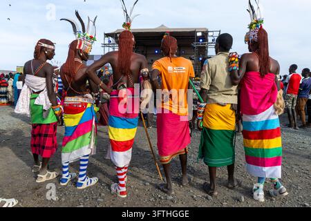 Vista posteriore di uomini della tribù Rendille con trecce di ocra rossa e copricapi piumati al Festival del Lago Turkana, Contea di Marsabit, Loiyangalani, Kenya Foto Stock