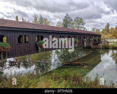 Ponte pedonale coperto in legno decorato con fiori sopra il fiume Ohre vicino al castello storico di Cheb nella città di Cheb, Repubblica Ceca, in una giornata autunnale nuvolosa. Foto Stock