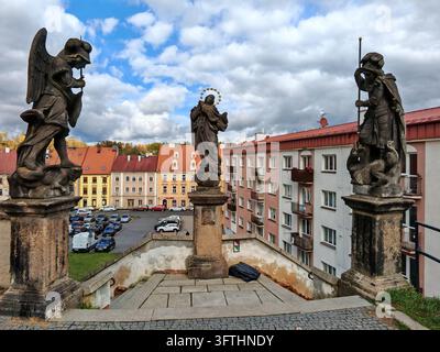 Statue religiose barocche in cima alle scale vicino alla chiesa di San Nicola che si affacciano su Piazza Kostelni nel centro storico di Cheb, Repubblica Ceca. Foto Stock