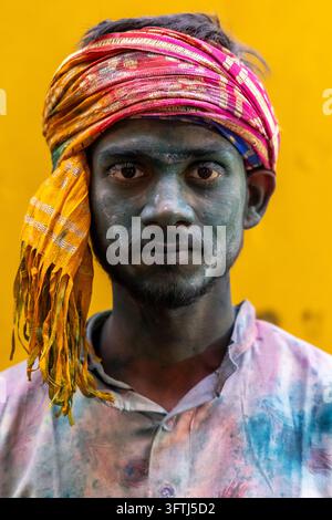 Ritratto di un giovane con il viso coperto di polvere grigio scuro che indossa un turbante magenta e arancione, Uttar Pradesh, Vrindavan, India Foto Stock