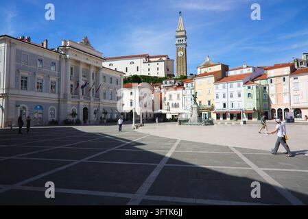 Municipio di Piran e piazza Tartini a Piran, in Slovenia, con la chiesa parrocchiale di San Giorgio e il campanile in cima alla collina sopra. Foto Stock