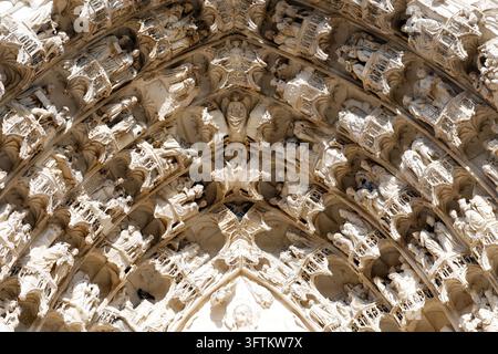 Una vista ravvicinata delle sculture in pietra gotiche che adornano il portale della cattedrale di Auxerre, con figure religiose, arcate finemente scolpite e archi Foto Stock