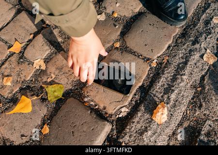 Tenere in mano un telefono rotto mentre si è in piedi su un sentiero di pietra Foto Stock