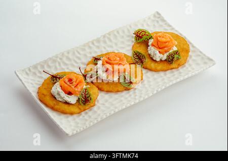 Eleganti canapè di salmone rosa su frittelle di patate Foto Stock