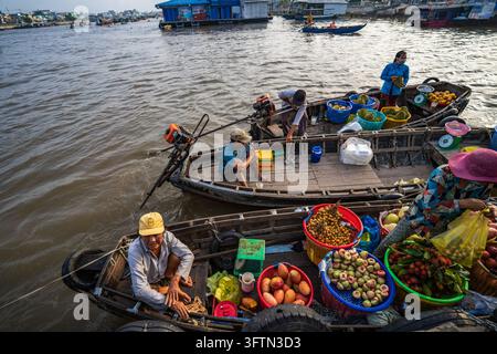 Vista ad angolo alto di barche di frutta legate insieme sul fiume con venditori che curano cesti di frutta tropicale, mercato galleggiante di Cai Rang, Can Tho, Vietnam Foto Stock