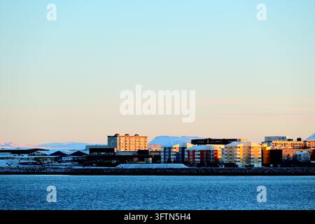 Edifici colorati sul lungomare e skyline urbana di Reykjavík, Islanda, su acque costiere calme alla morbida luce serale Foto Stock